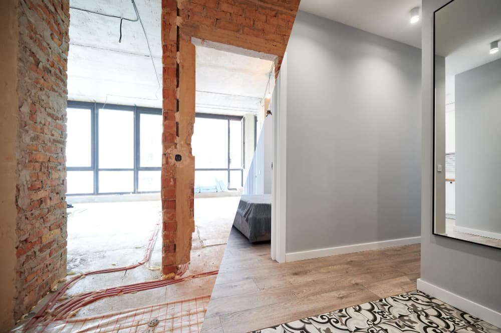 Muestra un cerramiento moderno de aluminio negro con cristal y estor blanco, junto a una puerta de entrada de madera marrón y un toldo retráctil negro sobre pared de ladrillo claro.